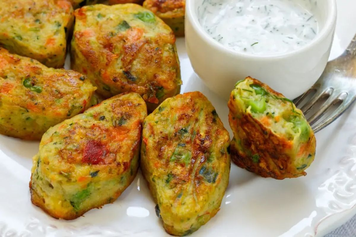 a close up of a plate of thai veggie bites next to a dish of white sauce