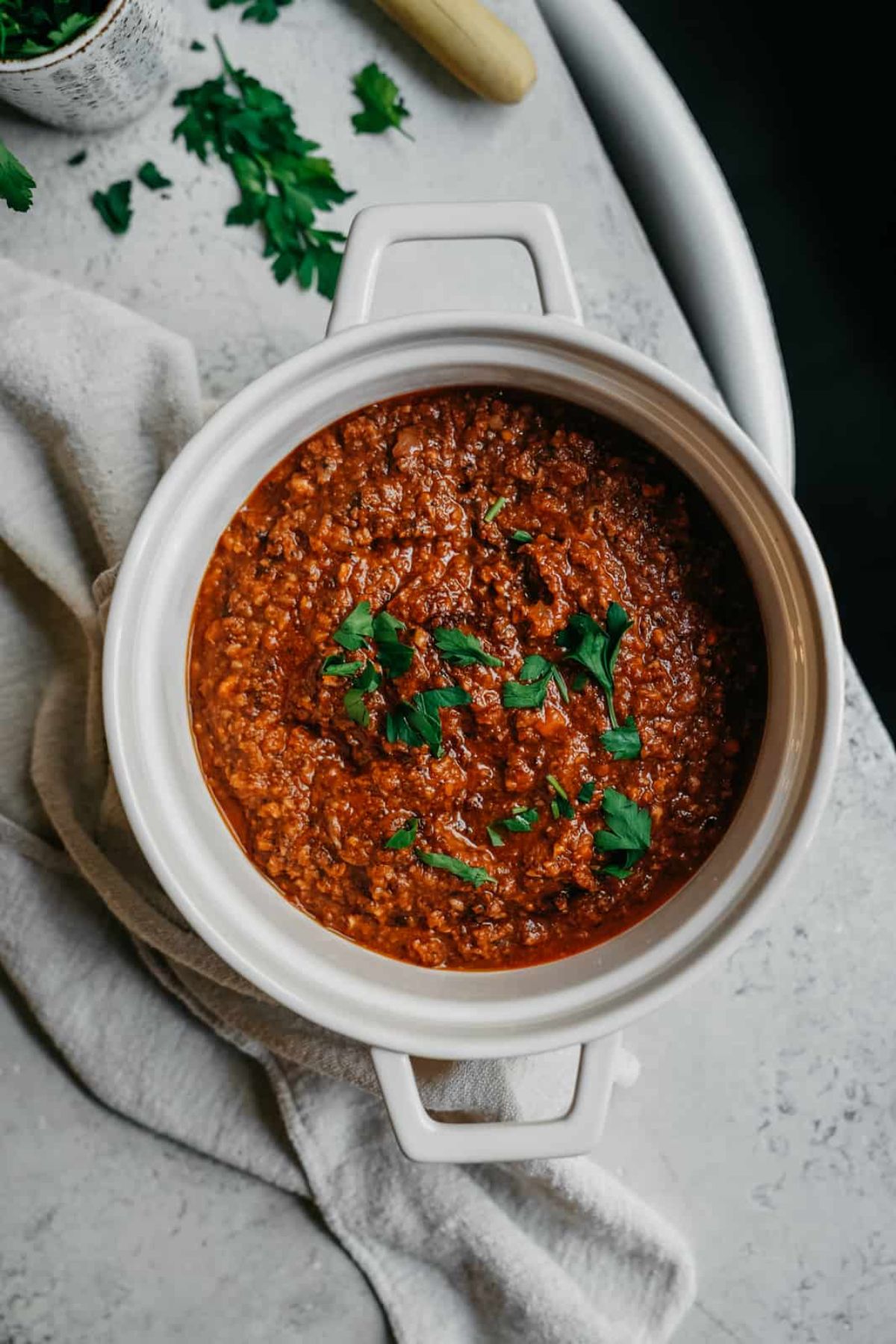 a casseroles dish of vegan "meat" sauce topped with fresh herbs