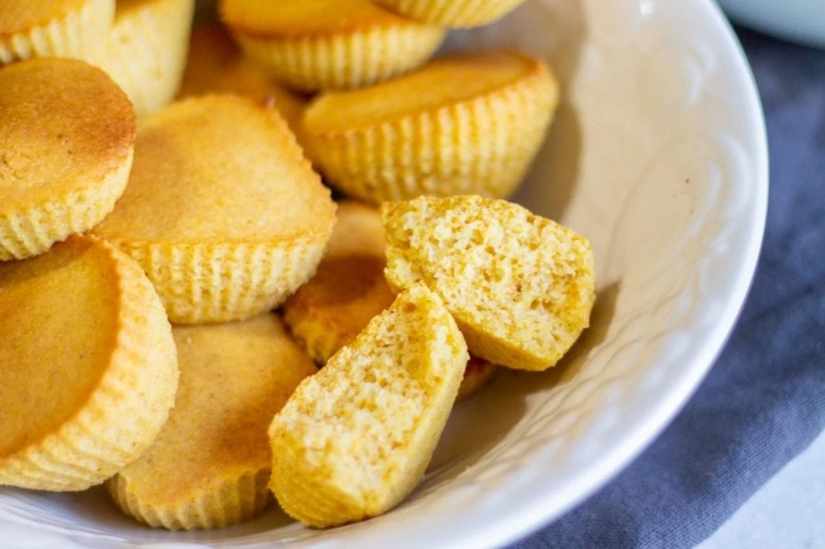 a close up of a white dish full of mini cornbread