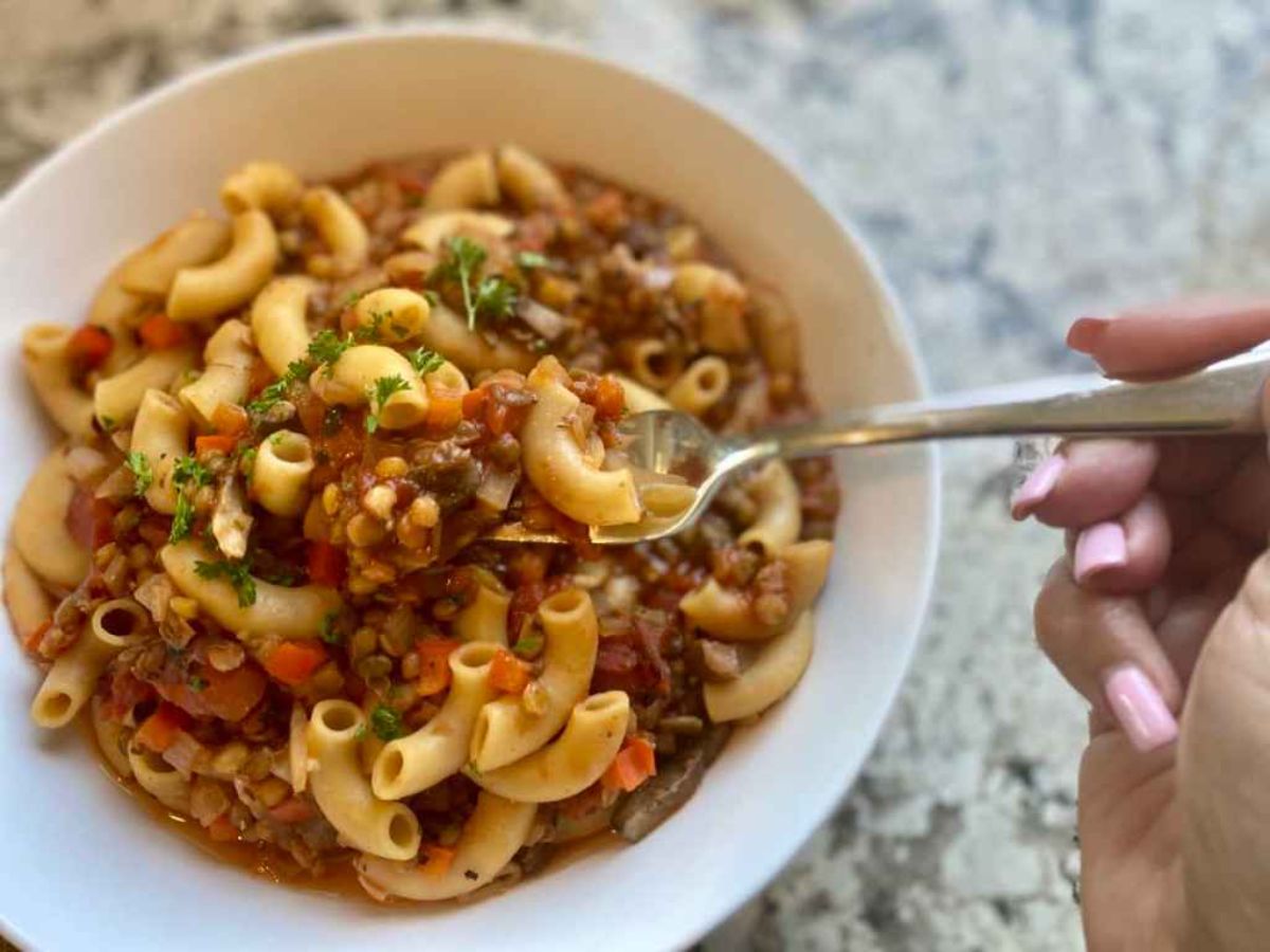 A bowl of vegan goulash with a spoon stuck in it