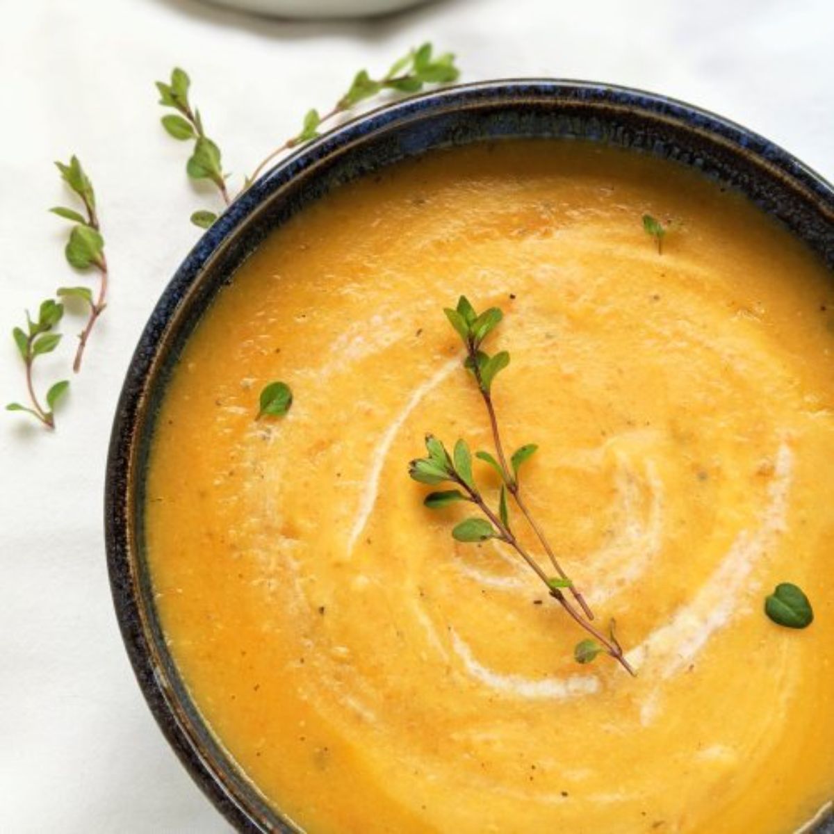 a black bowl full of carrot soup