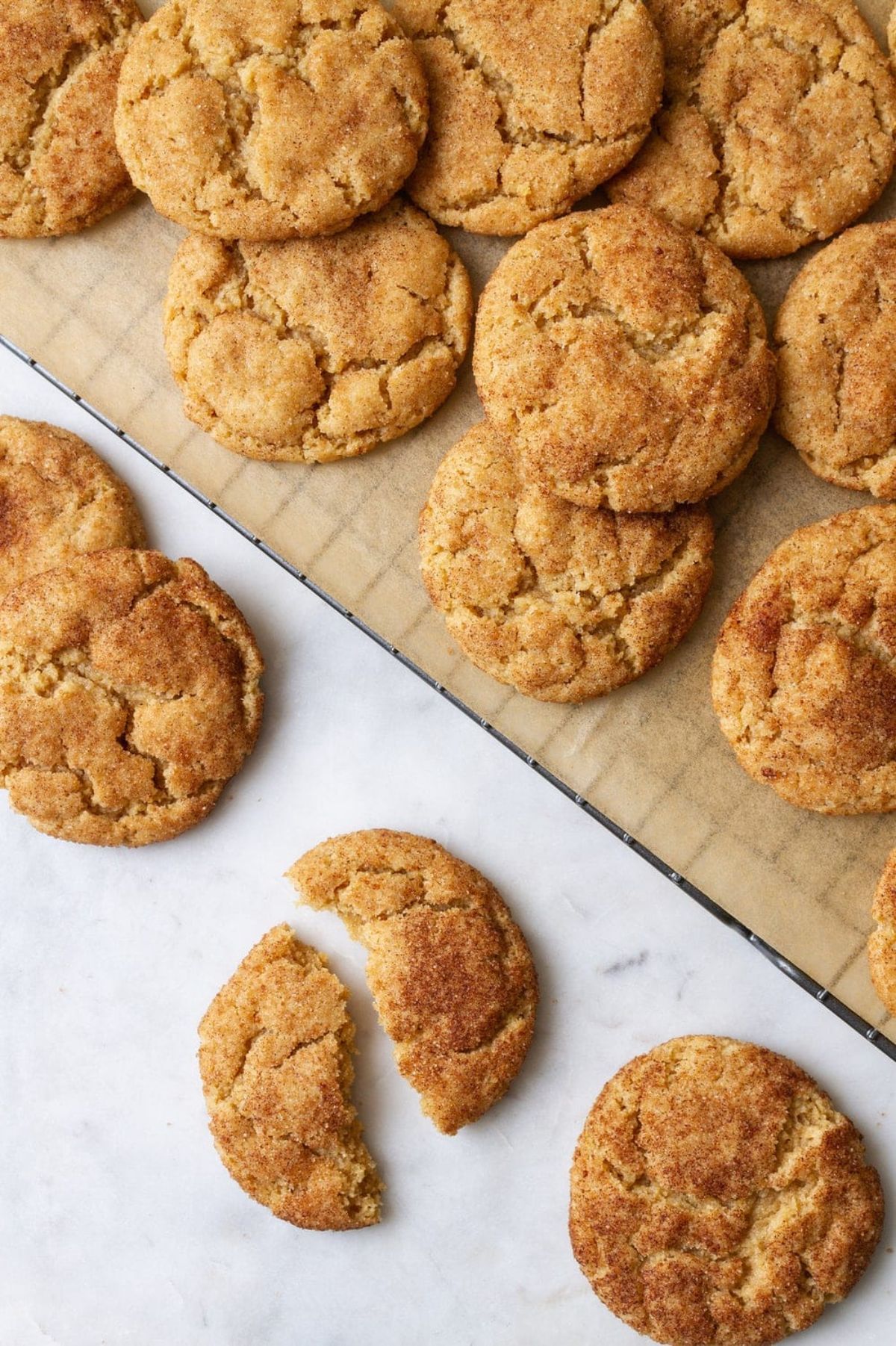 a cooling tray is full of snickerdoodles, some are in front of the tray