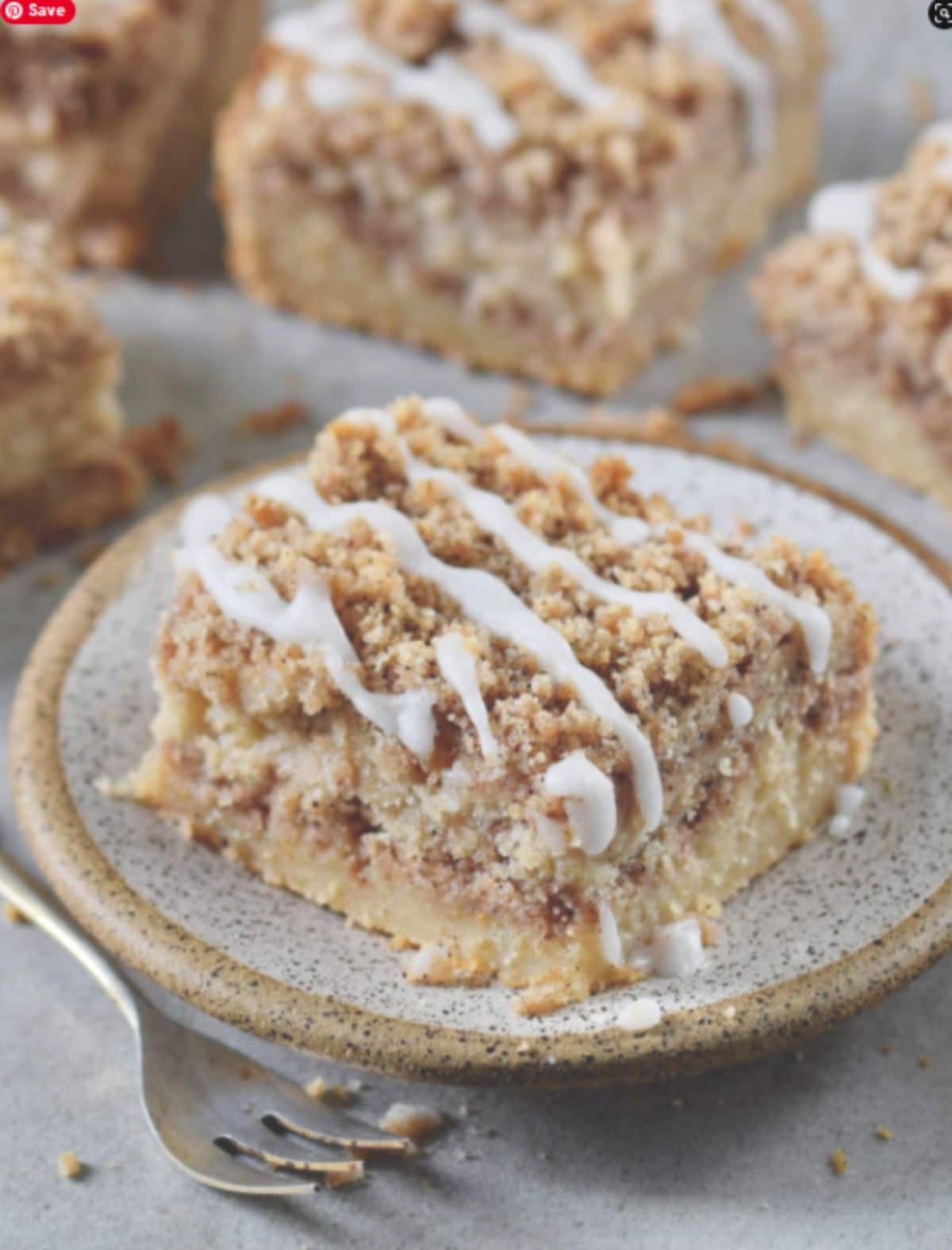 a plate with a slice of vegan coffee cake on it with more slices behins