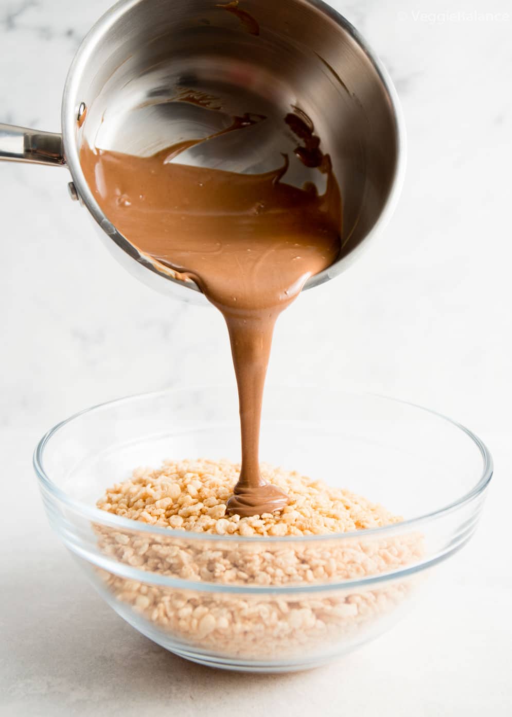 Peanut Butter Chocolate Rice Krispie Treats being prepared with chocolate being poured over rice krispie