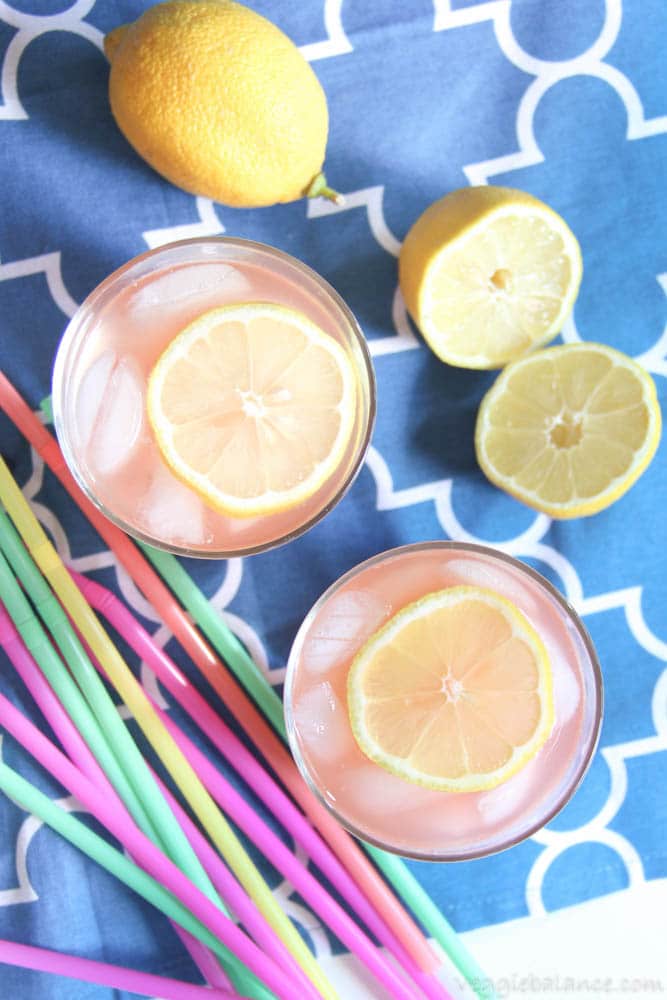 Healthy Lemonade in glasses with sliced lemon on blue background