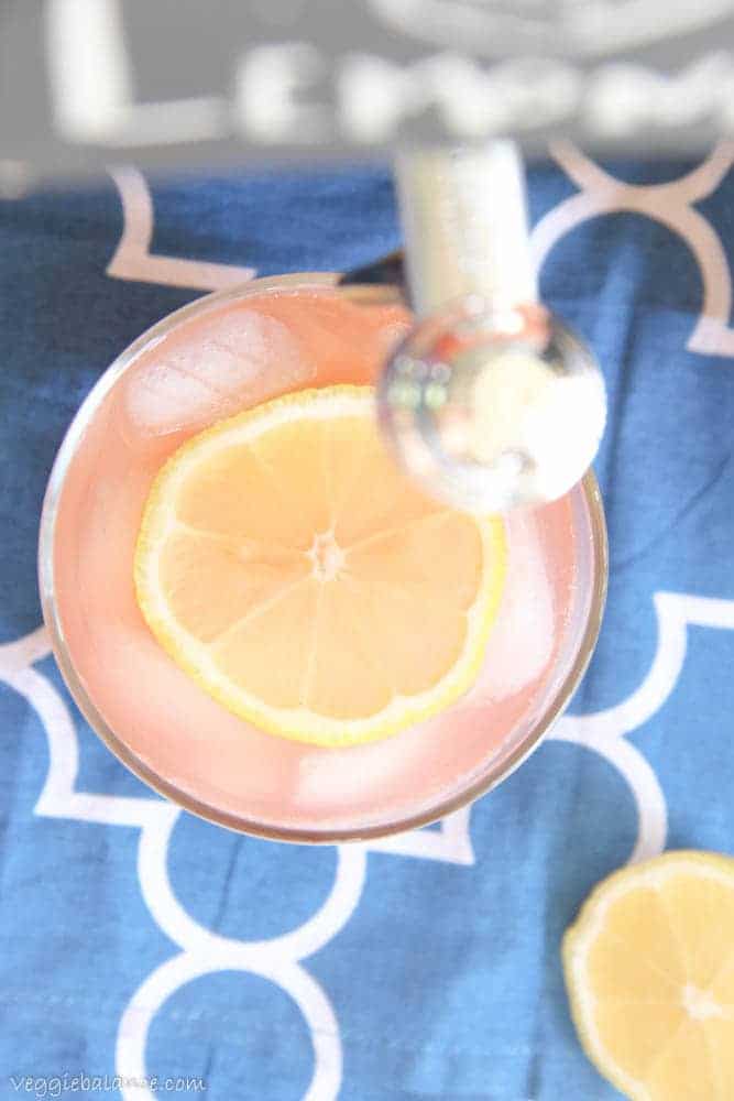 Healthy Lemonade in glasses with sliced lemon on blue background