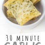 PINTEREST IMAGE with words "30 minute garlic butter bread" garlic butter bread stacked in a white bowl