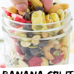 PINTEREST IMAGE with words "Banana Split Trail Mix" Image Banana Split Trail Mix in a glass jar with a pinch full being lifted out.