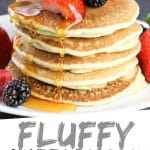 PINTEREST IMAGE with words "Fluffy Buttermilk Pancakes" Fluffy Buttermilk Pancakes stacked with strawberries and blackberries and syrup being poured over top