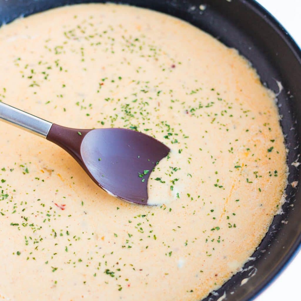 the perfect cheese sauce being prepared in a black skillet
