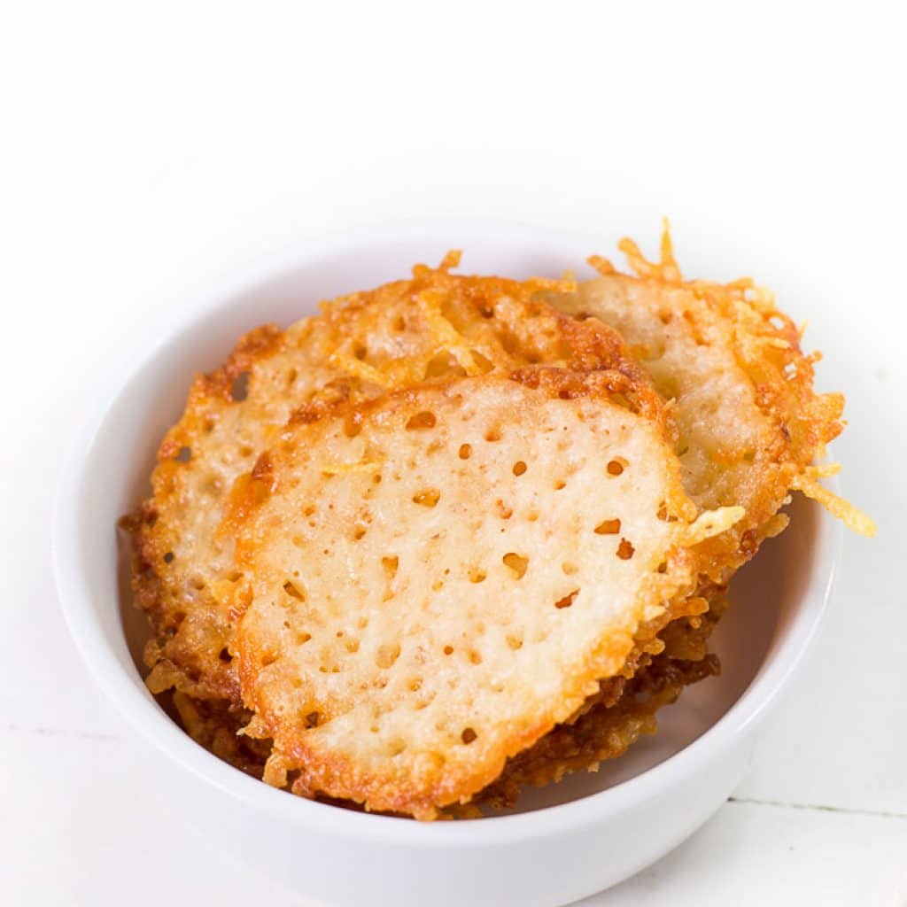 baked parmesan cheese crisps in a white bowl