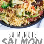 PINTEREST IMAGE with words "30 Minute Salmon Cajun Pasta" Salmon Cajun Pasta in a skillet with broccoli