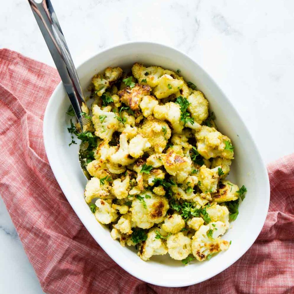 Overhead shot of Cheesy Vegan Roasted Cauliflower in a white bowl