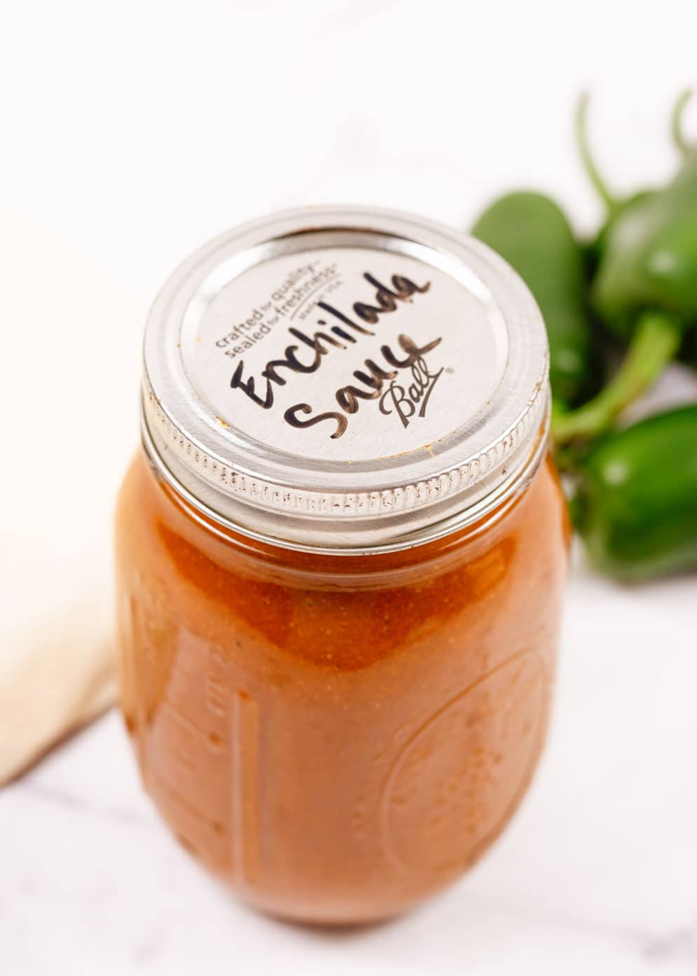Homemade Red Enchilada Sauce in a mason jar with lid written down as enchilada sauce