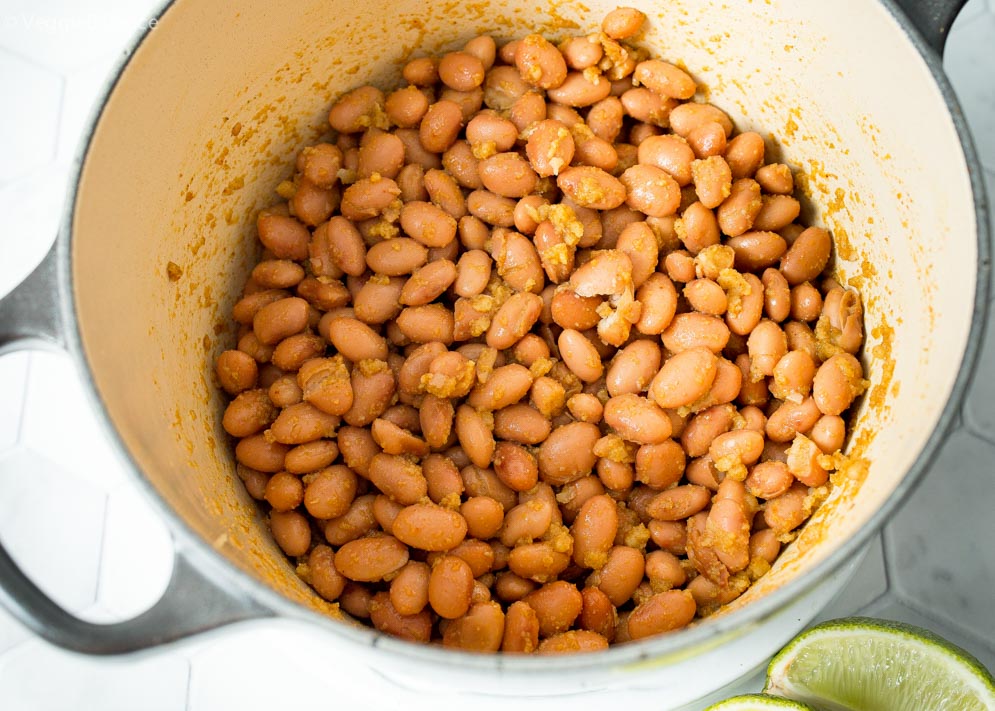 pot of pinto beans frying in oil to make refried beans