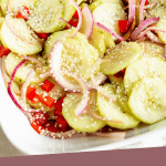 PINTEREST IMAGE with words "Plant Based Asian Cucumber Salad" Image Asian Cucumber Salad in white square bowl with wooden spoon