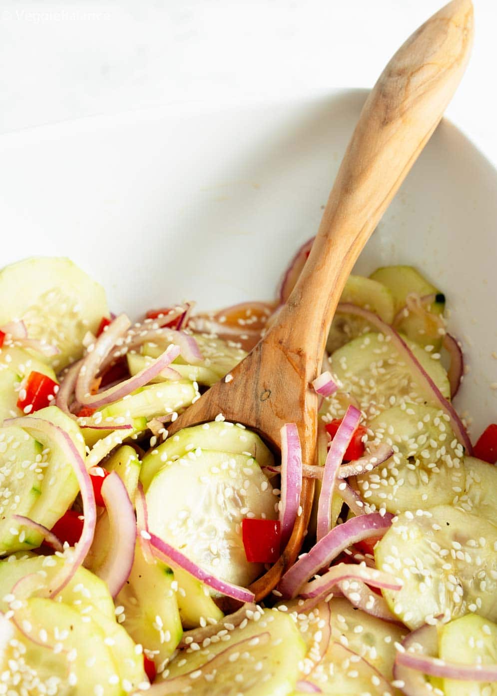 Bowl of Asian Cucumber Salad with wooden serving spoon