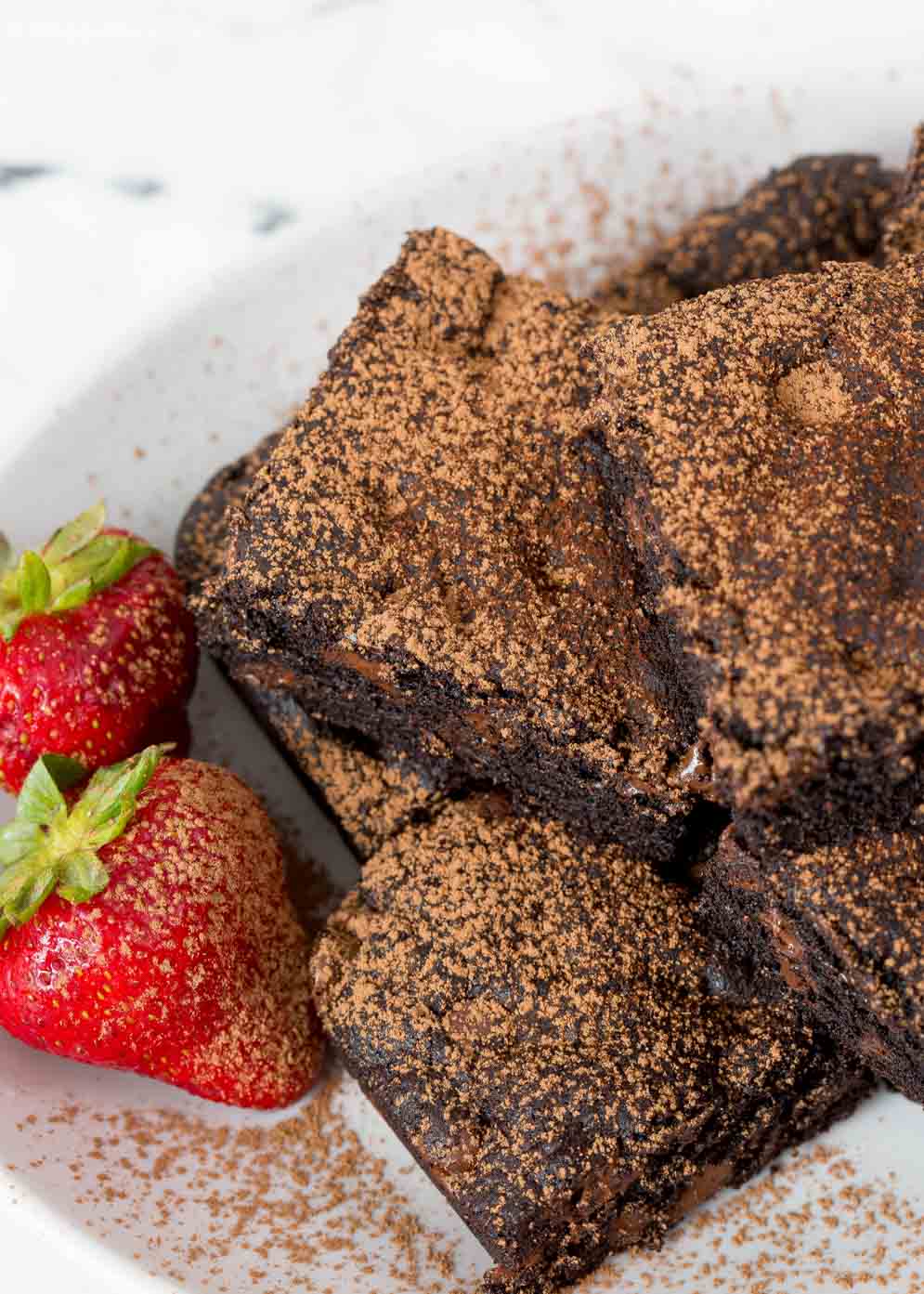 Plate of Vegan Brownies with strawberries on the side