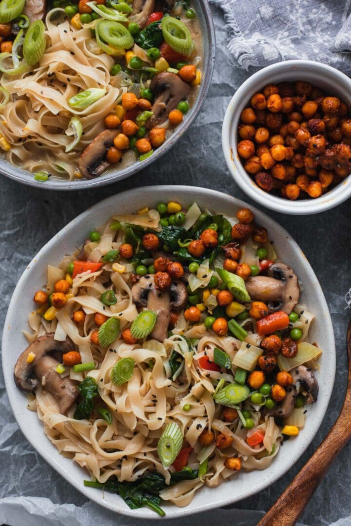 2 bowls full of noodle soup with roasted chickpeas. a bowl of chickpeas sits to the side