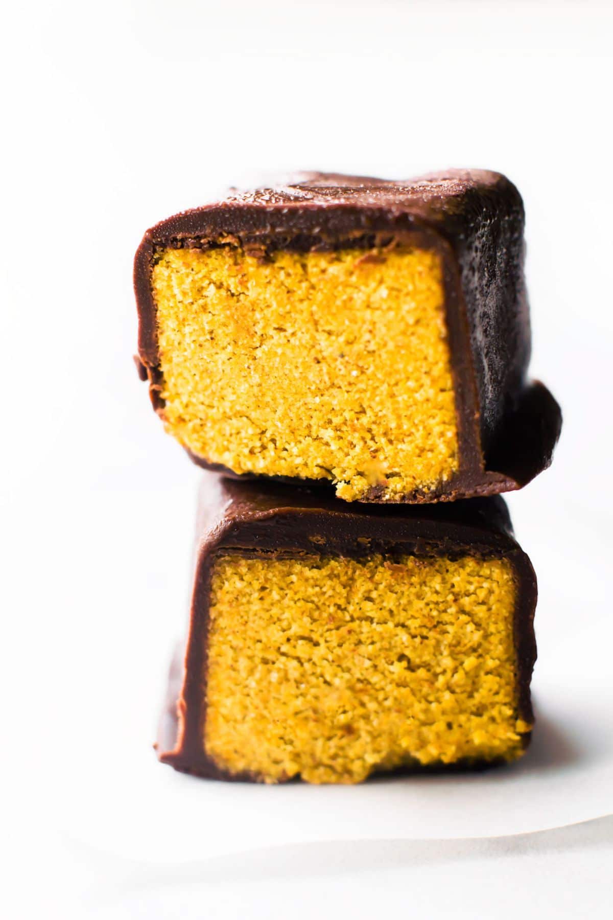 2 vegan pumpkin spice truffle bars cut in half to show their middles, sit on top of each other