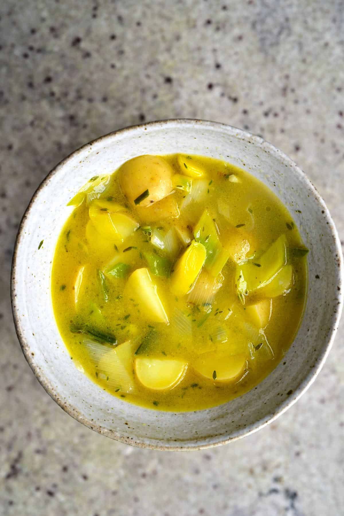 a white bowl full of potato and leek soup