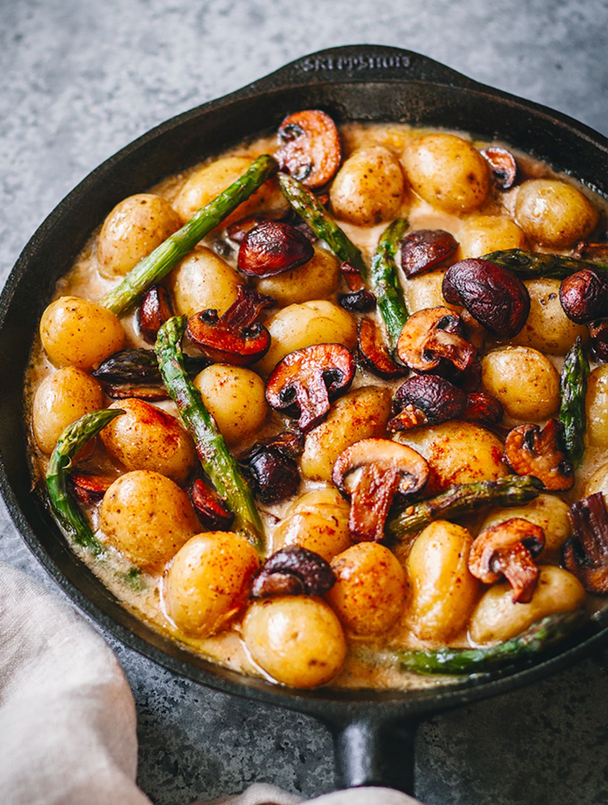 a cast iron skillet full of vegan mushroom gravy and potatoes