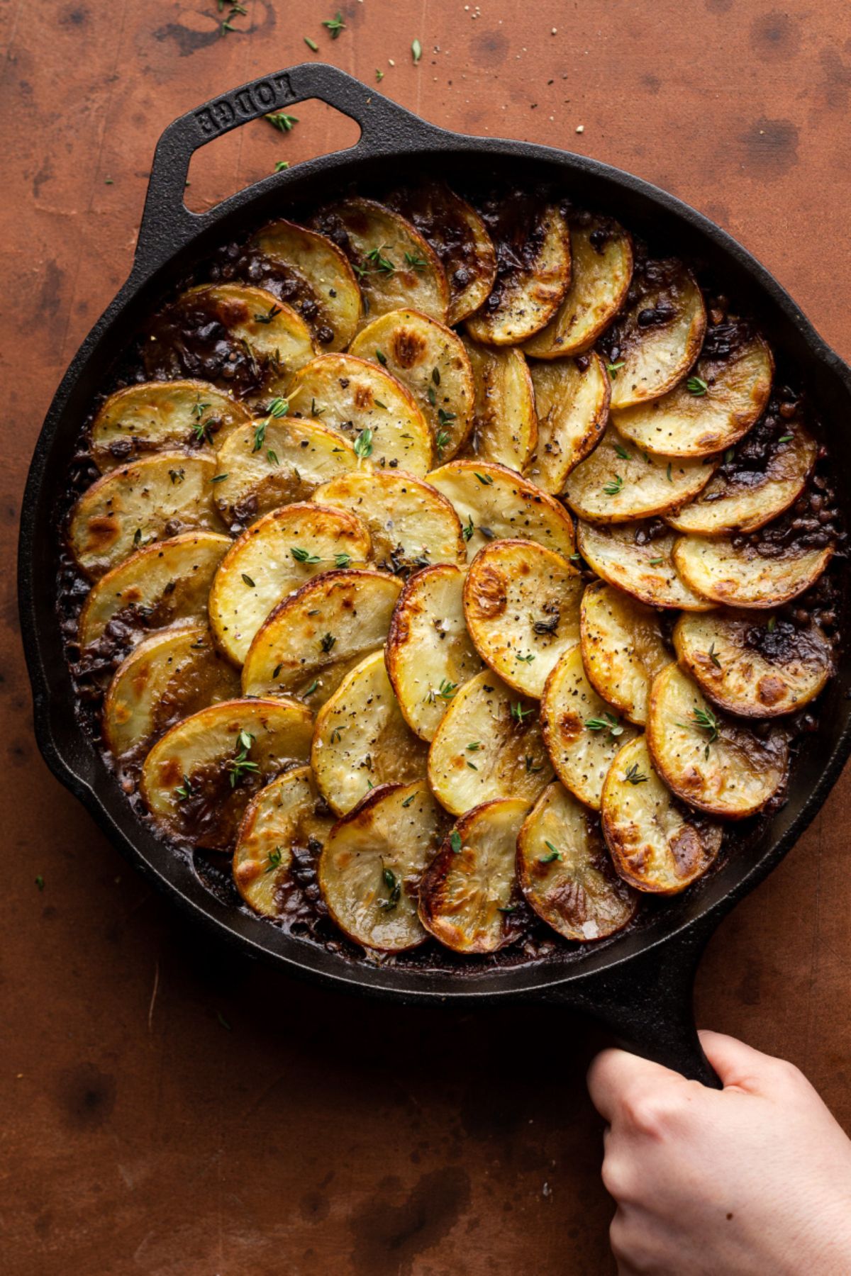 a cast iron skillet with a vegan mushroom and lentil hotpot inside it