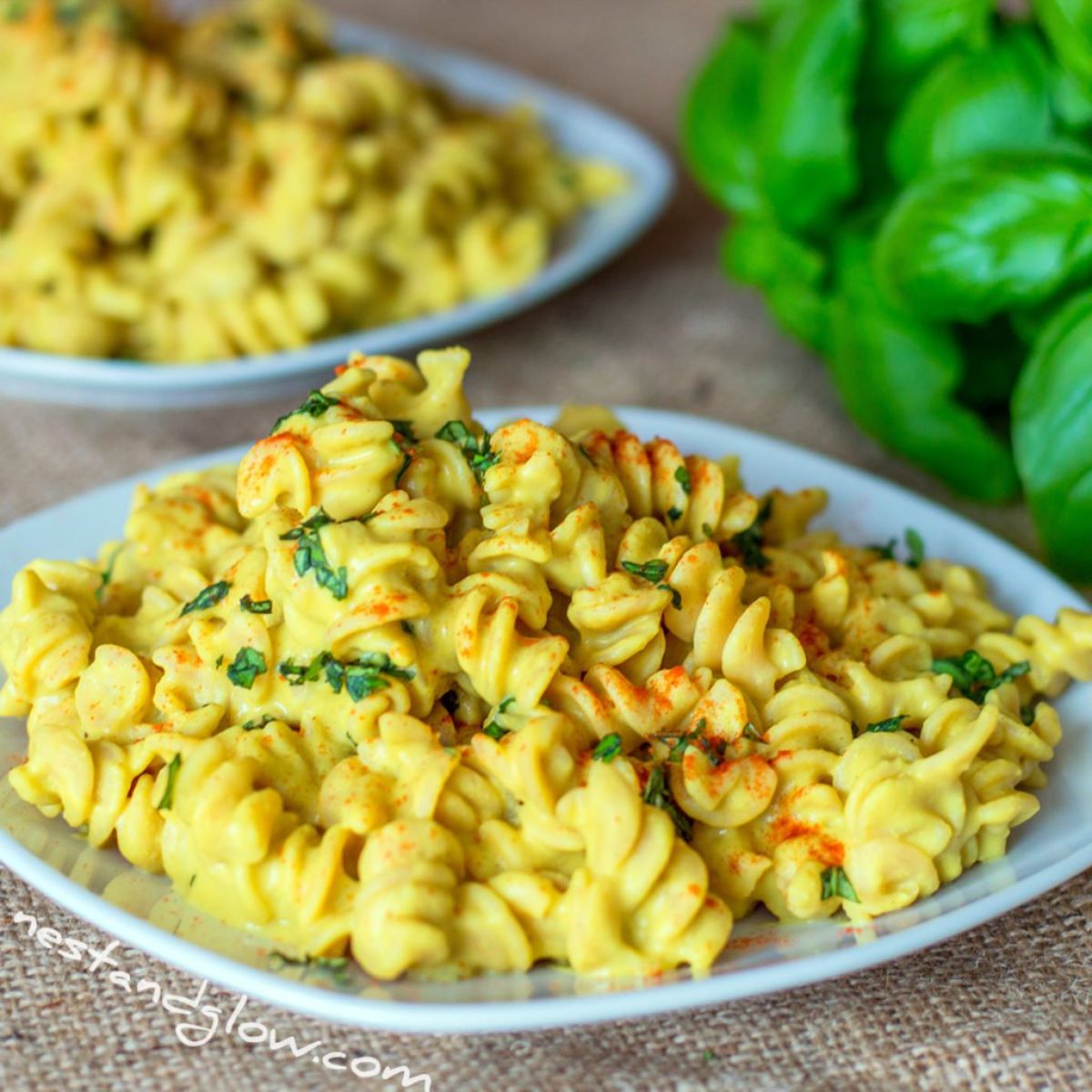 2 bowls of vegan protein pasta topped with chopped herbs