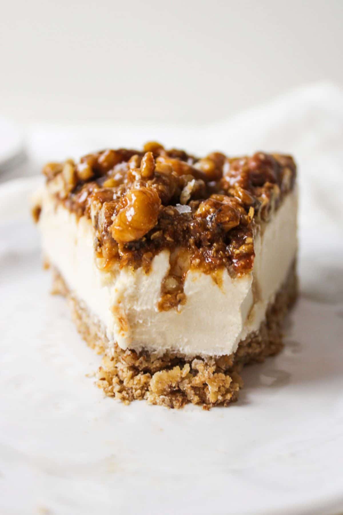 a close up of a slice of pecan pie cheesecake with the end missing